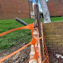 Close-up view of steel fencing pins securing safety barrier mesh.