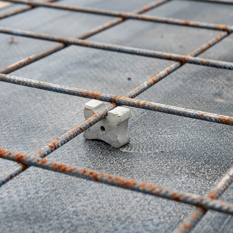 Close-up view of concrete reinforcement triple cover spacers in application