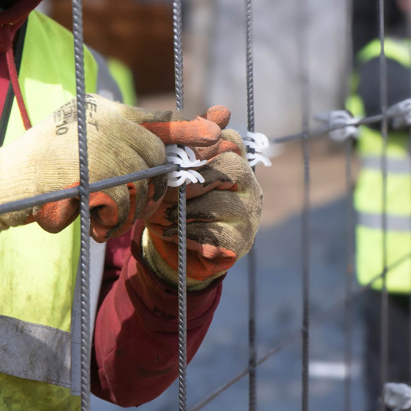 Concrete spacers with plastic clips installed on mesh for secure rebar support and precise positioning