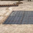 Deploying mesh spacers stools for concrete reinforcement during an on-site installation.