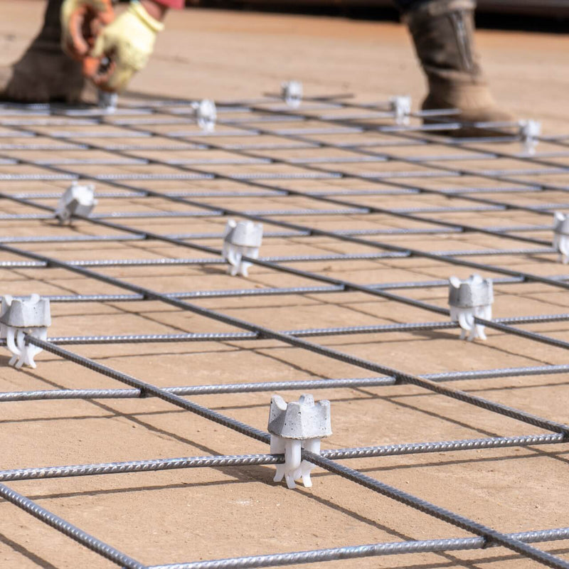 Setting up mesh for installation with concrete spacers with clips to ensure secure positioning and stability in construction